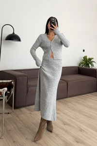 Dettaglio del set in maglia grigia a coste con cardigan scollo a V e gonna lunga