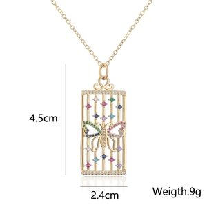 Detail shot of a hollow golden rectangle pendant featuring a colorful butterfly design