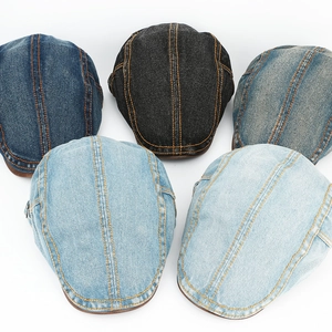 Flat lay of vintage washed denim newsboy caps in five shades with contrast stitching