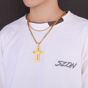 Close-up of gold cross pendant with double-layered stainless steel chains on model