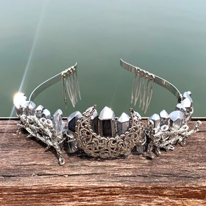 Detailed view of silver crystal crown featuring intricate metal moon and branch texture