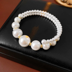 Détail macro du bracelet double couche en perles vintage avec perles dorées sur présentoir