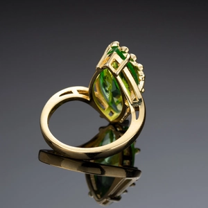 Lussuoso anello d'oro con pietra marquise verde smeraldo e dettagli geometrici cavi