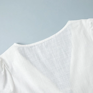 Detail of white cotton puff sleeve shirt with round neckline and textured fabric
