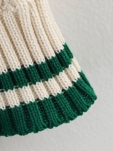 Macro detail of high-quality cream and dark green striped chunky knit sweater texture