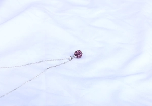 Detailansicht eines lila Kristall Shamballa Kugelanhängers an einer Silberkette
