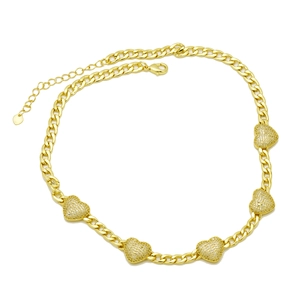 Detail view of gold Cuban chain necklace featuring five rhinestone encrusted heart charms