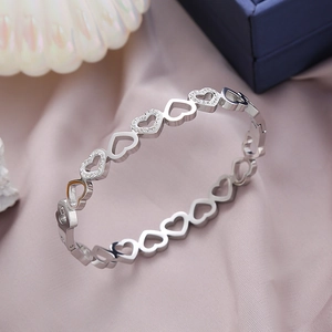 Polished silver heart hollow bracelet with micro pave zircon on soft silk background