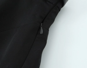 Detailed macro view of the side zipper closure on black halter neck top fabric