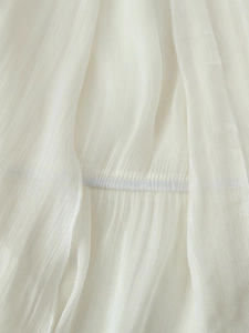 Detailed macro view of white pleated fabric texture with vertical seams and soft finish
