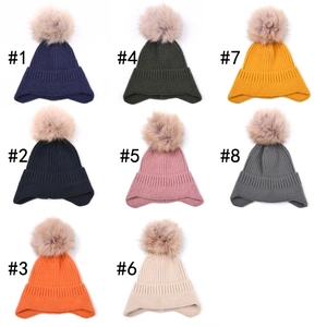 Outdoor warm knitted earflap hats in eight assorted colors with large fluffy pom-poms