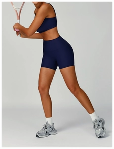 Detail view of high-waist ribbed yoga shorts and sports bra in deep blue fabric