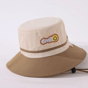 Detail of embroidered smile patch and adjustable windproof cord on kids bucket hat