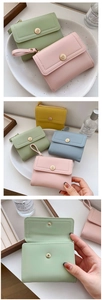 Detail of short tri-fold PU leather wallets in pastel colors with floral snap buttons
