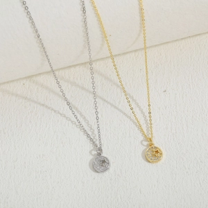 Macro detail of gold and silver necklaces featuring star-patterned zircon pendants