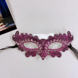 Close-up of intricate lace embroidery texture on rose red masquerade eye mask