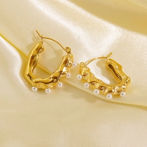 Lava texture gold earrings with pearls on glossy silk fabric in a French vintage style