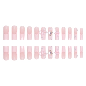 Pink French press-on nails with heart rhinestones and pearl bow accents in a 24-piece set