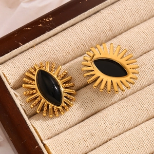 Macro shot of 18K gold plated stainless steel sunburst earring with black onyx stone inlay