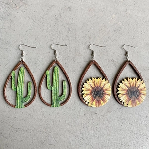 Teardrop wooden earrings featuring cactus and sunflower prints on a gray textured background