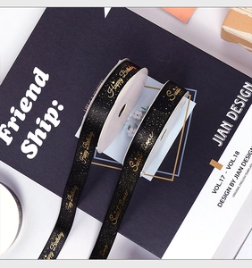 Close-up of black polyester gift ribbons with gold stamped Happy Birthday lettering