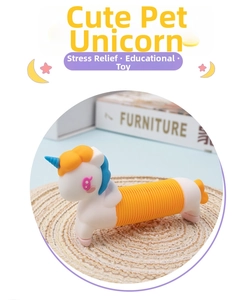 Detail shot of unicorn pop tube sensory toy with flexible orange bellows on woven mat