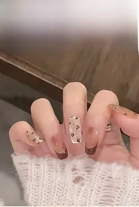 Close-up of leopard print and brown gradient press-on nails with gold foil details