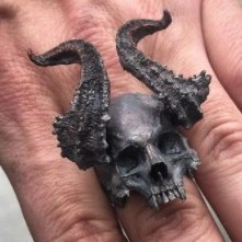 Macro detail of gothic sheep horn skull ring with dark oxidized vintage silver finish