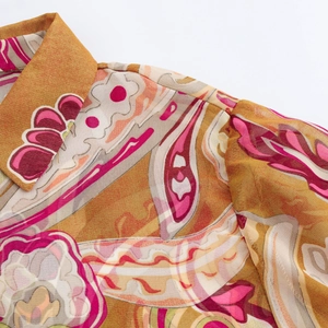 Close-up of neckline and shoulder on yellow paisley chiffon blouse with floral pattern