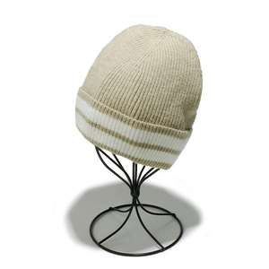 Détail montrant la texture en maille côtelée et rayures blanches du bonnet beige