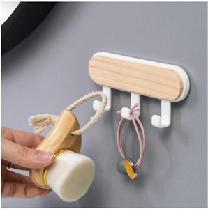 Japanese style wooden wall hook rack with three white hooks and elastic band storage