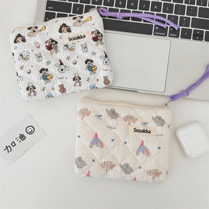 Detailed view of quilted floral pouches with cute dog and elephant prints on desk