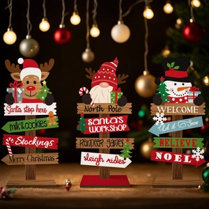 Detailed view of Christmas wooden signs featuring elk, gnome, and snowman in warm lighting