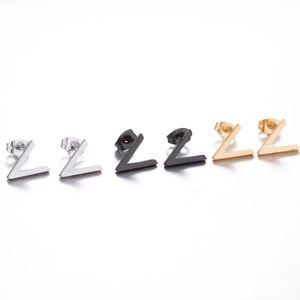 Detailed view of minimalist V-shaped stud earrings in silver, black, and gold steel