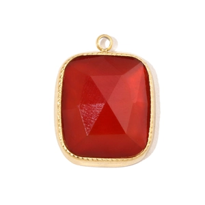 Macro detail of faceted red gemstone pendant with gold plated rectangular frame