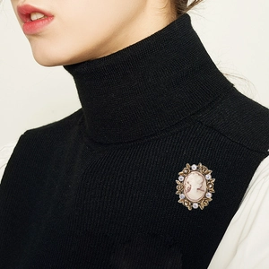 Vintage oval cameo brooch with crystal flowers on a black turtleneck sweater