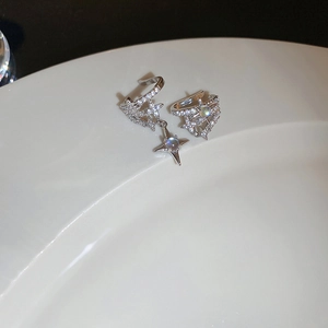 Makroaufnahme von silbernen Zirkon-Ohrklemmen mit Mondstein und asymmetrischem Stern-Design