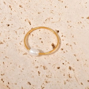 Dettaglio macro di un anello vintage placcato oro con perla d'acqua dolce naturale bianca