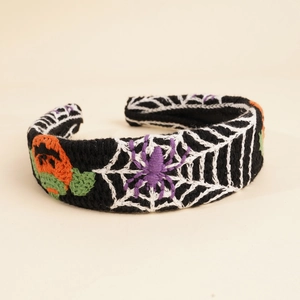 Detailed close-up of Halloween knit headband with pumpkin, spider and web embroidery