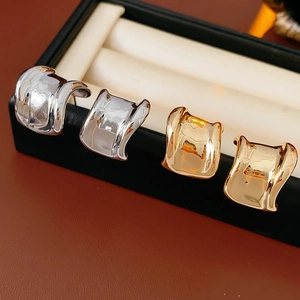 Makroaufnahme von gold- und silberfarbenen geometrischen Ohrringen in einer Box