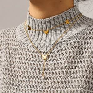 Close-up of double-layer butterfly pearl necklace on a model wearing a grey sweater