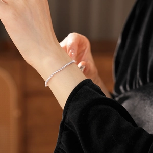 Macro shot of elegant silver-gray beaded bracelet on wrist with French vintage style