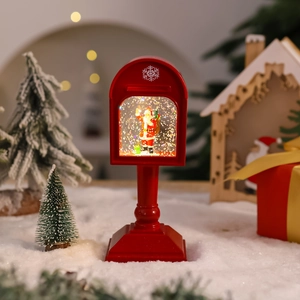 Close-up of a lit Christmas mailbox snow globe with Santa Claus and festive glitter