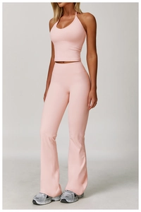 Detail of pink halter sports top and high-waisted flare yoga pants set on model