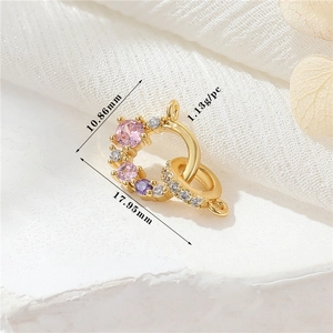 Dettaglio del ciondolo in oro 14K con incastonate pietre preziose rosa e viola