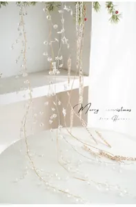 Close-up of acrylic snowflake beads and golden star ornaments on a pine branch