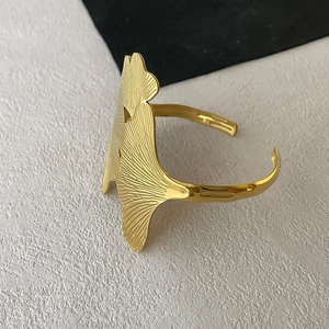 Detailed close-up showing the golden ginkgo leaf texture and vein patterns on the cuff bracelet