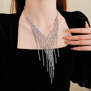 Detail of silver V-shaped tassel necklace with sparkling zircons on a model's neckline