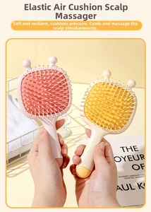 Detail of pink and beige cartoon bee massage hairbrushes with cute ear designs