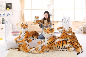 Detailed plush tiger toys in various sizes shown in a cozy indoor home setting
